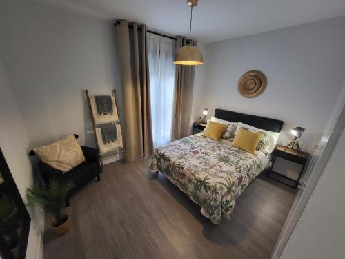 1 dormitorio con 1 cama y 1 silla en Alazán Jerez II-Parking gratis-wifi-Netflix, en Jerez de la Frontera