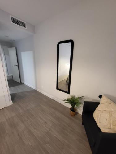 a living room with a mirror and a couch at Alazán Jerez II-Parking gratis-wifi in Jerez de la Frontera