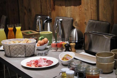 einen Tisch mit Teller mit Lebensmitteln auf einer Theke in der Unterkunft Auberge de Cassiel in La Côte-dʼAime