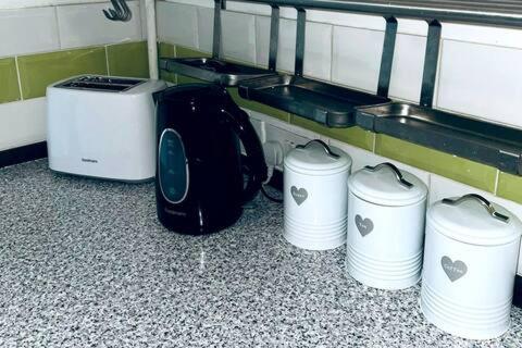 a group of four toasters on the floor in a room at Comfortable town house in Coventry City Centre in Coventry