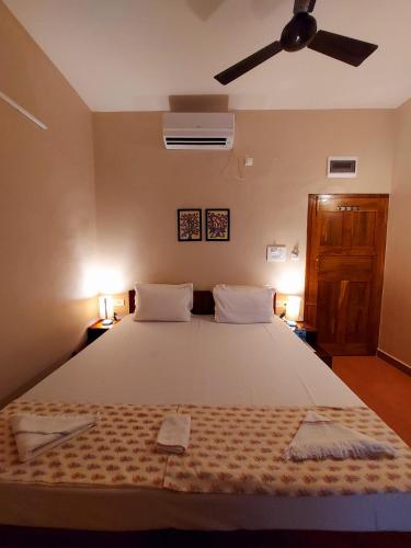 a bedroom with a large white bed with two pillows at OmBodhi Retreat in Kumta