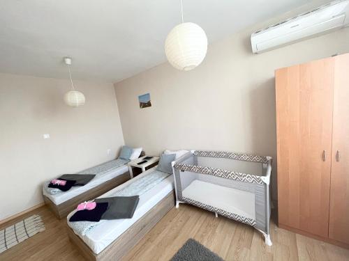 a room with two beds in a room with lights at Airport Apartment in Sofia
