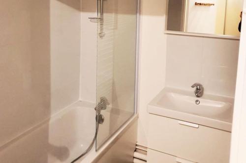 a white bathroom with a shower and a sink at Le Jules Val - Studio cosy en résidence + Parking + Wi-fi in Évry-les-Châteaux