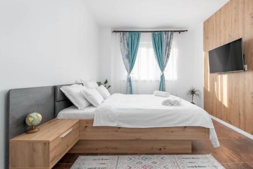 una camera con letto e TV a parete di Talida's apartment colorful and brightnes a Oradea