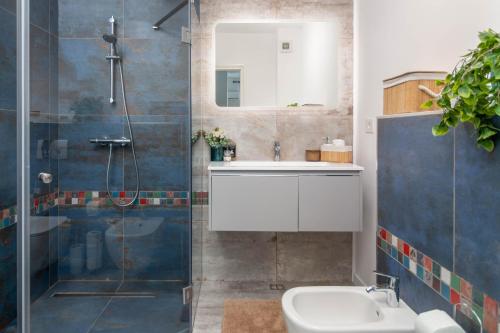 uma casa de banho com um lavatório e um chuveiro em Talida's apartment colorful and brightnes em Oradea