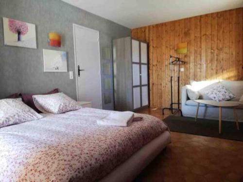 um quarto com uma cama grande e uma cadeira em Gîte La Saulce T3 avec vue sur les montagnes em La Saulce