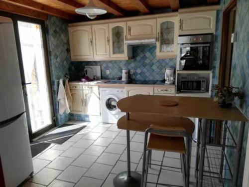 uma cozinha com armários brancos e uma mesa com cadeiras em Gîte La Saulce T3 avec vue sur les montagnes em La Saulce