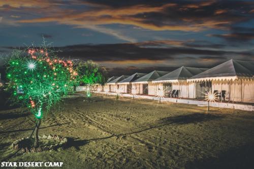 a christmas tree in front of a row of tents at Star Desert Camp Jaisalmer in Jaisalmer