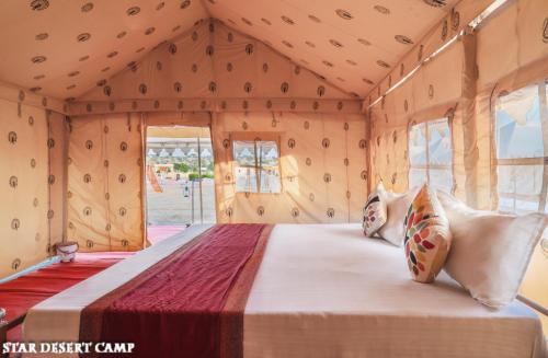 a bedroom in a caravan with a bed and windows at Star Desert Camp Jaisalmer in Jaisalmer