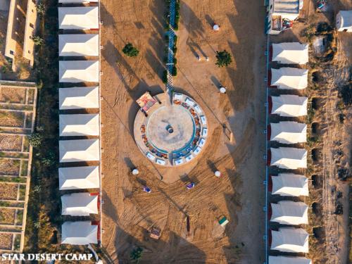 an overhead view of a building in a field with houses at Star Desert Camp Jaisalmer in Jaisalmer