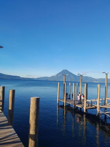 a group of people sitting on a dock on the water at Hostal Dulces Sueños in Panajachel