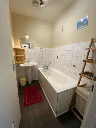 La salle de bains blanche est pourvue d'une baignoire et d'un lavabo. dans l'établissement La grande marmite du lac de Vouglans, à Pont-de-Poitte