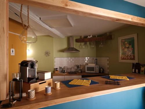 a kitchen with a counter top with a microwave at Petit cocon quartier historique Chaumont in Chaumont