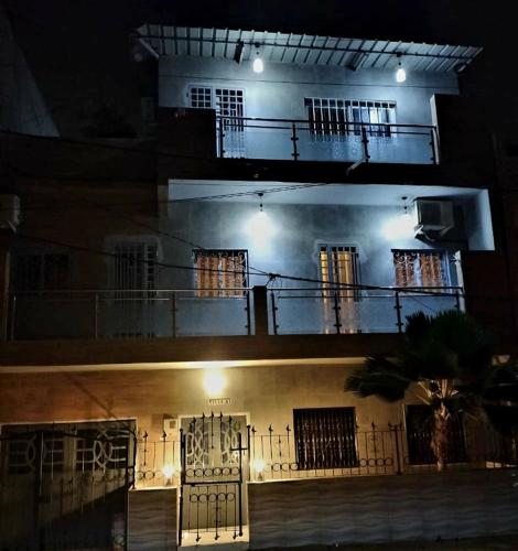 a building with a balcony and a gate at night at Maison d'Hôtes entière Cité Douane Golf Dakar in Dakar