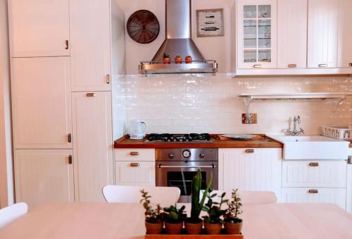 a kitchen with white cabinets and a stove at Sweet home tuscany in Bientina