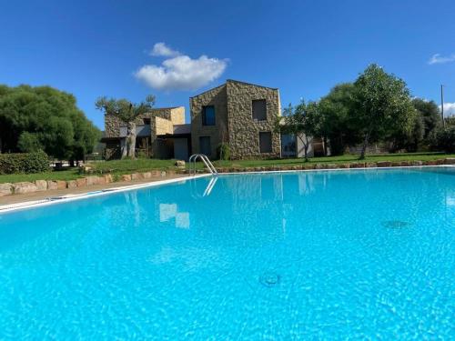 una gran piscina azul frente a una casa en Casa Barbara Sardinia, en Masainas