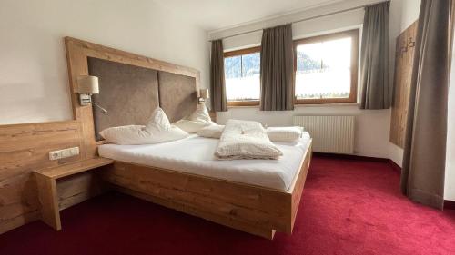 レンゲンフェルトにあるLandhaus Ennemoserのベッドルーム1室(白いシーツ付きのベッド1台、窓付)