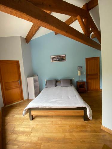 ein Schlafzimmer mit einem Bett in einem Zimmer mit Holzböden in der Unterkunft Fontanilles in Cabrerolles