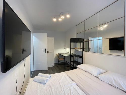 a bedroom with a bed and a tv and a desk at Cozy Apart - Self check-in 24h in Wrocław