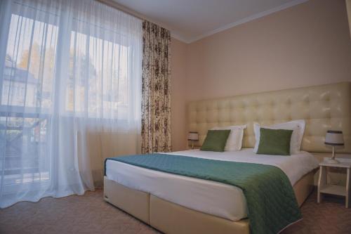 a bedroom with a large bed with a large window at Hotel&Restaurant Premium Club in Yaremche