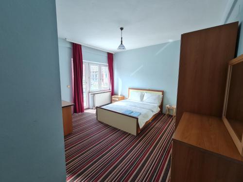 a bedroom with a bed and a large window at Holiday in Ferizaj
