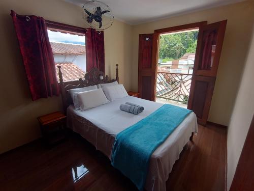 een slaapkamer met een bed en een groot raam bij Casa com piscina em condomínio in Paraty