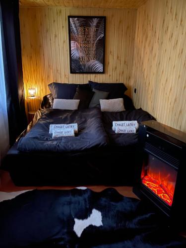 a bed in a room with a fire place at Chalet Látky in Látky