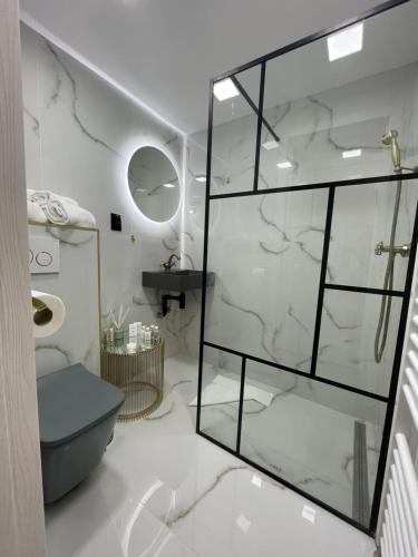 a bathroom with white marble walls and a toilet at Chalet Látky in Látky