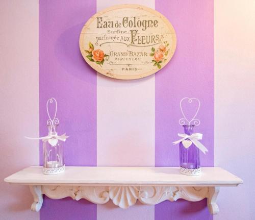 two vases on a shelf with a sign on a wall at Sweet home tuscany in Bientina