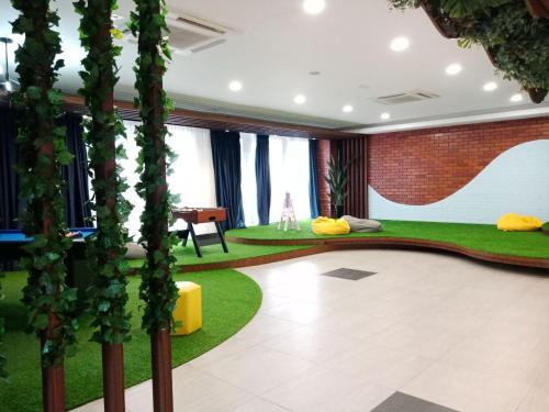 a room with a green floor and plants at Staycationbyrieymona - 3BR Condo, CLIO 2, Putrajaya in Putrajaya