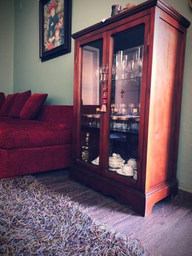 a red cabinet with a glass door and a red couch at Village House Grevena in Grevena