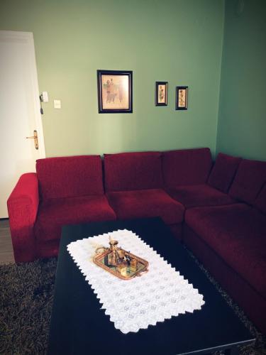 a living room with a red couch with a cake on a table at Village House Grevena in Grevena