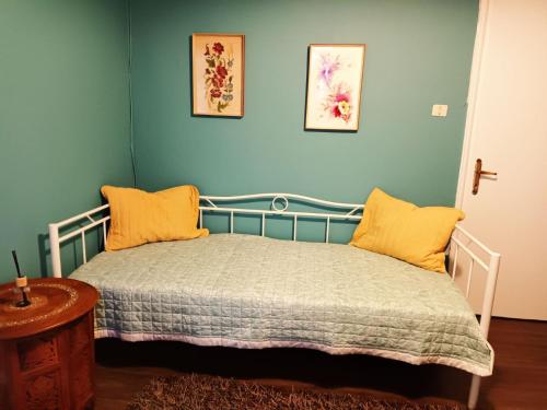 Un dormitorio con una cama con almohadas amarillas. en Village House Grevena en Grevena