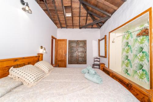 a bedroom with a large bed with a wooden headboard at Casa Buganvilla in Hermigua
