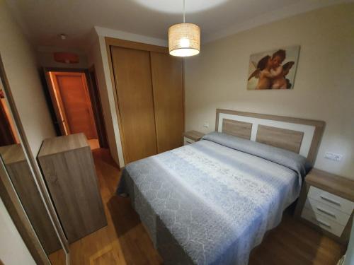 um quarto com uma cama com um cobertor azul em MHC em Boiro