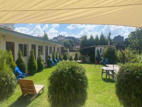 une cour avec des chaises et une table ainsi qu'un bâtiment dans l'établissement Ocean Inn, à Katmandou