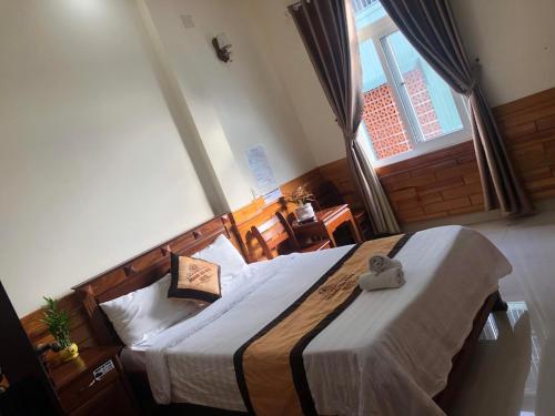a bedroom with a bed and a large window at Hoàng Gia Bảo Hotel in Kon Tum