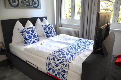 a bed with blue and white pillows on it at Apartman Favorita in Vienna