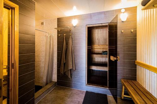 uma casa de banho com uma cabina de duche ao nível do chão e uma cabina de duche ao nível do chão em Marupes pirts em Mārupe