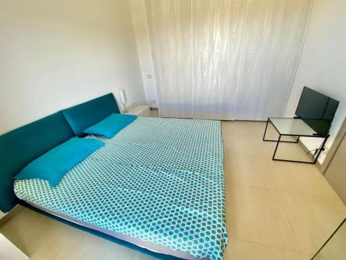 niebieskie łóżko w pokoju ze stołem w obiekcie Casa Barbara Sardinia w mieście Masainas