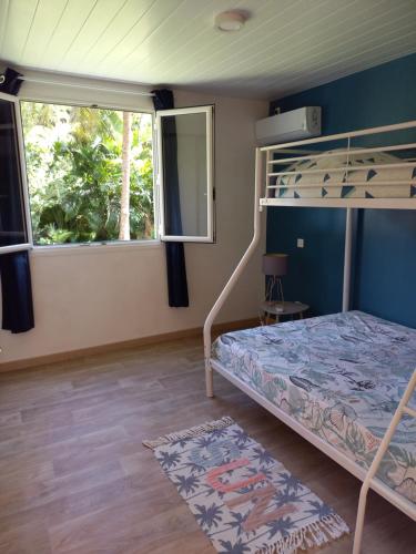 ein Schlafzimmer mit einem Etagenbett und einem Fenster in der Unterkunft T3 les Alpinias in Rivière-Salée