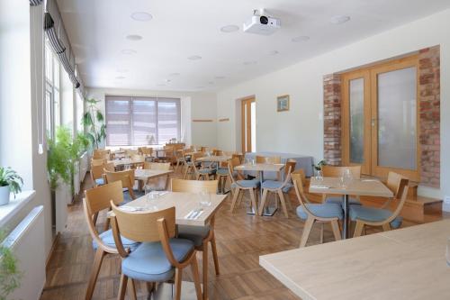 un restaurante con mesas y sillas en una habitación en Penzion Harmony Javorník en Čtyřkoly