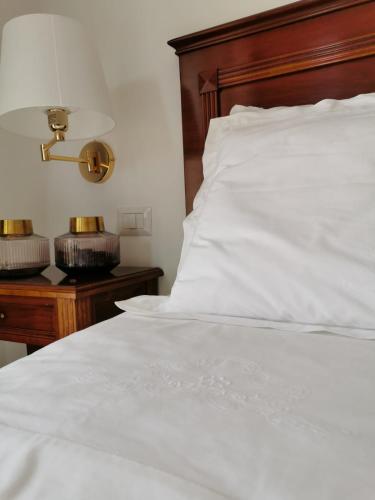 a white bed with a wooden headboard next to a table at B&B Le Torri in Santeramo in Colle