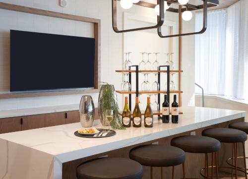 a bar with bottles of wine and stools at Staybridge Suites Wilmington Downtown by IHG in Wilmington