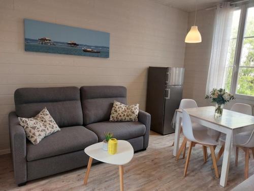 a living room with a couch and a table at APPARTEMENT 4 PERSONNES ARCACHON in Arcachon