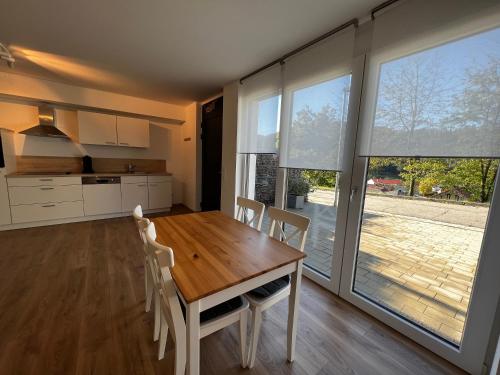 cocina y comedor con mesa de madera y sillas en Ferienhaus Marve en Ettenheim