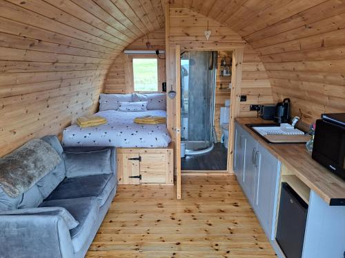 Aultgrishin的住宿－Shiskine Pod，一间小房间,配有沙发和厨房,位于一个小房子里