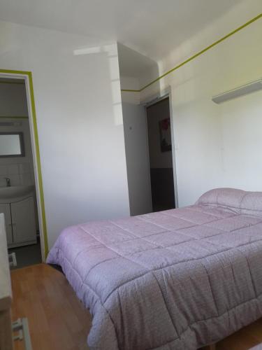 - une chambre avec un lit et une couverture violette dans l'établissement AUBERGE DU RELAIS, à Écardenville-la-Campagne