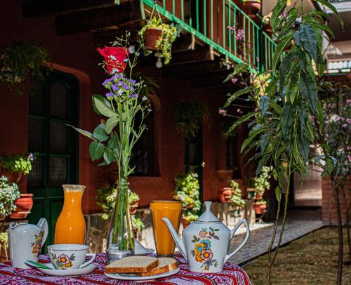 a table with vases and sandwiches and flowers on it at Hotel Willcamayu in Pisac