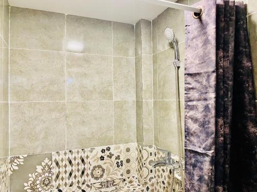 a bathroom with a shower with a shower curtain at Like Home Hostel na Shevchenko, 162Б in Almaty